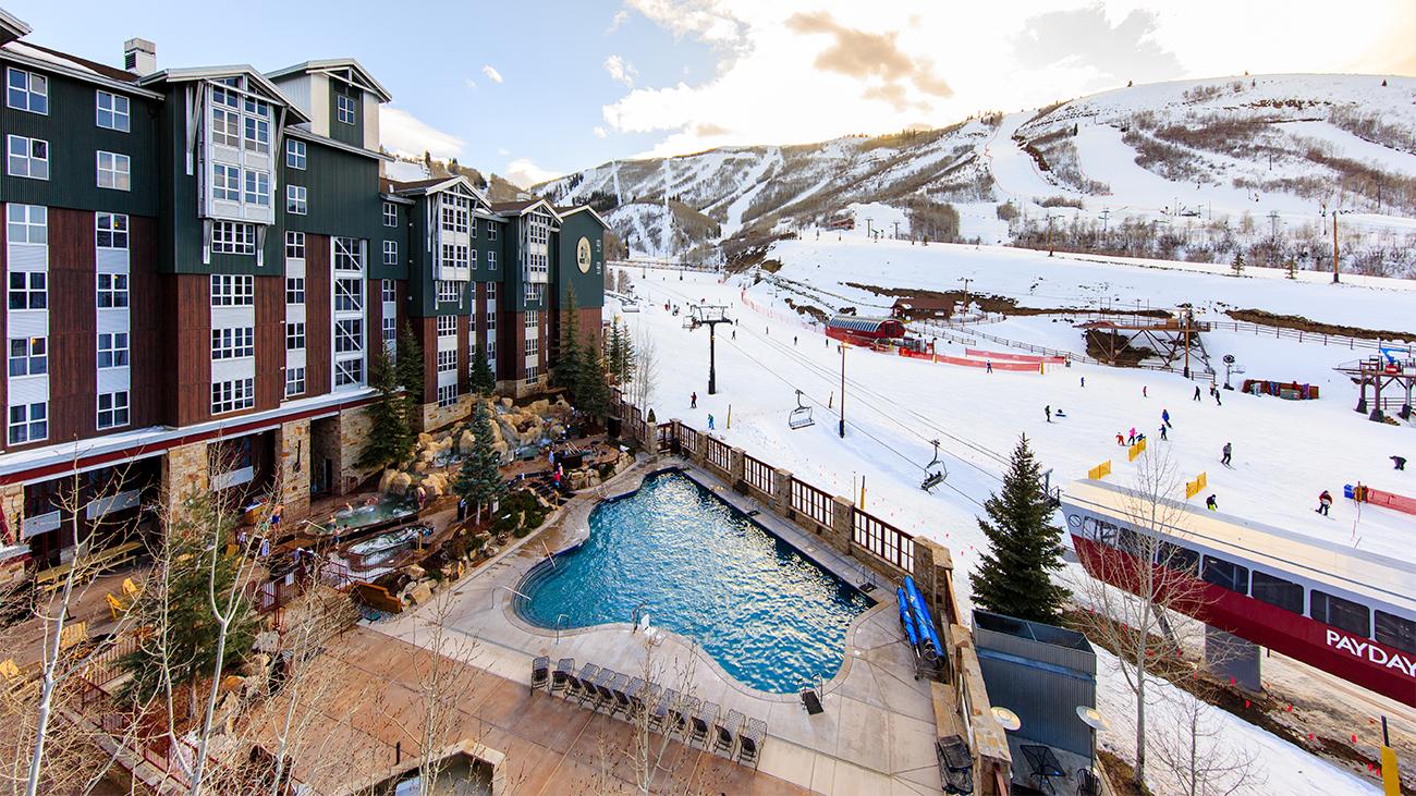 Exterior of Marriott's Mountainside resort timeshare showing pool, ski lifts and snow-clad mountains in background